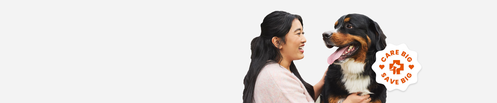A woman smiling at her Burmese Mountain dog during a photoshoot